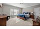 Bedroom with a large window, light-colored carpet, and a wooden bed with blue and white bedding at 4008 Quintessa Dr, Matthews, NC 28104