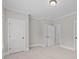 Neutral bedroom with white trim, doors, and plush carpet, perfect for creating a tranquil retreat at 4008 Quintessa Dr, Matthews, NC 28104
