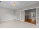 Bright bonus room with neutral carpet, crown molding, and double French doors at 4008 Quintessa Dr, Matthews, NC 28104