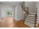 Elegant foyer features hardwood floors, staircase with iron spindles, and arched entry to formal living area at 4008 Quintessa Dr, Matthews, NC 28104