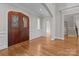 Inviting foyer with a wood front door, hardwood floors, and white trim at 4008 Quintessa Dr, Matthews, NC 28104