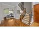 Foyer showcasing hardwood floors, stairs with carpet and wooden railing, and entry to dining room at 4008 Quintessa Dr, Matthews, NC 28104