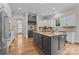 Gourmet kitchen with gray island, white cabinets, and stainless steel appliances at 4008 Quintessa Dr, Matthews, NC 28104