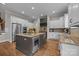 Modern kitchen with island, wine fridge, stainless appliances, and white cabinets at 4008 Quintessa Dr, Matthews, NC 28104