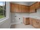 Bright laundry room with upper and lower maple cabinets, a white countertop, and a utility sink at 4008 Quintessa Dr, Matthews, NC 28104