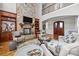 Open-concept living room with a stone fireplace, built-in shelving, and a view of the upstairs balcony at 4008 Quintessa Dr, Matthews, NC 28104