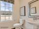 Stylish bathroom with a pedestal sink, toilet and window providing natural light at 4084 Skyboat Cir, Fort Mill, SC 29715