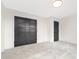 A bedroom with neutral carpet, a simple light fixture, and closet with gray accent door at 4605 Western Union School Rd, Waxhaw, NC 28173