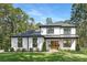 Stunning two-story modern farmhouse with black trim, wood accents, a lush lawn, and mature trees at 4605 Western Union School Rd, Waxhaw, NC 28173