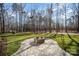 An outdoor fire pit in a beautiful landscaped backyard with mature trees and green grass at 4605 Western Union School Rd, Waxhaw, NC 28173