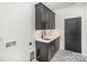 Practical laundry room featuring dark cabinets, modern fixtures, and stylish patterned tile flooring at 4605 Western Union School Rd, Waxhaw, NC 28173