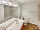 Bathroom with double vanity, a bathtub, and neutral tile floors at 4903 Greenloch Ct, Monroe, NC 28110