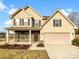 Two-story house with a beige exterior, stone accents, and a two-car garage at 4903 Greenloch Ct, Monroe, NC 28110