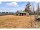 Wooden barn with stalls and green roof at 499 Indian Hill Rd, Olin, NC 28660