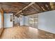 Living room with hardwood floors, rustic ceiling, and sliding glass doors at 499 Indian Hill Rd, Olin, NC 28660