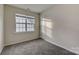 Well-lit bedroom featuring neutral walls, carpet, and a window with blinds at 5813 Bridgeway Dr, Indian Trail, NC 28079