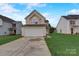 Two-story house with a beige exterior, attached garage, and a well-maintained lawn at 5813 Bridgeway Dr, Indian Trail, NC 28079