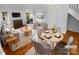 Virtually staged living room with hardwood floors, fireplace, and dining area at 609 Mountainwater Dr, Charlotte, NC 28262