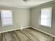 Well-lit bedroom with hardwood floors and two windows at 624 Windy Hill Dr, Gastonia, NC 28052