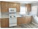 Galley kitchen with white appliances and wood cabinets at 624 Windy Hill Dr, Gastonia, NC 28052