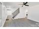 Living room with modern staircase, vinyl flooring, and access to other rooms at 6309 Spring Garden Ln, Charlotte, NC 28213