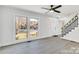 Living room with gray vinyl flooring, modern staircase, and large windows at 6309 Spring Garden Ln, Charlotte, NC 28213