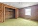 Bedroom with wood paneling, green carpet, and closet at 643 Alf Hoover Rd, Lincolnton, NC 28092