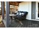 Back porch area with wicker seating with floral patterned pillows, a small table, and a view of the yard at 670 Allenton St, Norwood, NC 28128