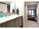 A bathroom with a marbled vanity, silver hardware and fixtures, and a clear view to an adjoining den area at 670 Allenton St, Norwood, NC 28128