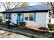 Charming home exterior with a metal roof, blue door and shutters, and well-maintained landscaping at 670 Allenton St, Norwood, NC 28128