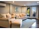 A cozy living room featuring beige sofas, neutral walls, a bright painting, and a view of a lakeside deck at 670 Allenton St, Norwood, NC 28128