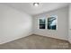 Cozy bedroom featuring neutral carpeting and a window at 7015 Cardigan Ave, Charlotte, NC 28215