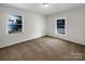 Bright bedroom with neutral carpeting and two windows at 7015 Cardigan Ave, Charlotte, NC 28215