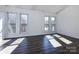 Spacious bedroom with three windows and dark gray vinyl flooring at 7912 Charter Oak Ln, Charlotte, NC 28226