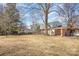 Spacious backyard featuring dormant grass, bare trees, and a partial view of the home's rear exterior at 821 Greentree Dr, Charlotte, NC 28211