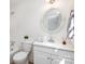 Bathroom with a tiled shower, a white vanity, a framed round mirror, and neutral paint at 821 Greentree Dr, Charlotte, NC 28211