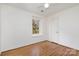 Bright bedroom featuring hardwood floors, white walls, trim and doors, and a window with natural light at 821 Greentree Dr, Charlotte, NC 28211