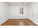 Bright bedroom featuring hardwood floors, white walls, trim and doors, and a window with natural light at 821 Greentree Dr, Charlotte, NC 28211