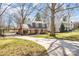 Two-story brick home with a long driveway, mature trees, and a well-maintained lawn at 821 Greentree Dr, Charlotte, NC 28211