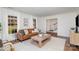 Bright living room featuring a leather sofa, stylish decor, and large windows that let in natural light at 821 Greentree Dr, Charlotte, NC 28211