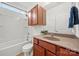 Bathroom with tub and shower, wooden vanity and sink, and white toilet at 8312 Compton Acres Ln, Waxhaw, NC 28173