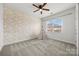 Bright bedroom with modern wallpaper, neutral carpet, ceiling fan, and large window at 8312 Compton Acres Ln, Waxhaw, NC 28173