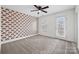 Bedroom with a large window, patterned accent wall, and ceiling fan at 8312 Compton Acres Ln, Waxhaw, NC 28173