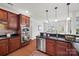 Kitchen area with stainless steel appliances, dark countertops, and warm wooden cabinetry at 8312 Compton Acres Ln, Waxhaw, NC 28173