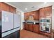 Kitchen with stainless steel oven and microwave, cherry cabinets, granite counters, and modern fridge at 8312 Compton Acres Ln, Waxhaw, NC 28173