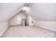 Spacious attic featuring neutral walls, carpet, and a stairway entrance, providing flexible living space at 102 W Vista View Pl, Mooresville, NC 28117