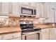 Close-up of the stove and microwave with stylish countertops and cabinetry at 102 W Vista View Pl, Mooresville, NC 28117