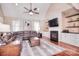 Bright living room features a fireplace, modern ceiling fan, and comfortable leather sectional at 102 W Vista View Pl, Mooresville, NC 28117