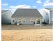 Backyard view featuring the home's exterior, patio, and a spacious grassy area at 1036 Barnette Farm Ln, Monroe, NC 28110