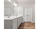 Bright bathroom with double sink vanity, white countertops, and a large mirror at 1036 Barnette Farm Ln, Monroe, NC 28110